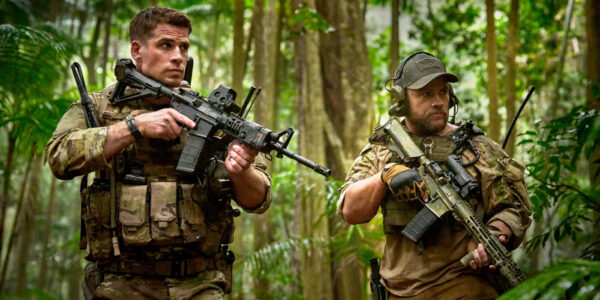 Liam Hemsworth and Luke Hemsworth walking in the jungle with their guns in Land of Bad | Agents of Fandom