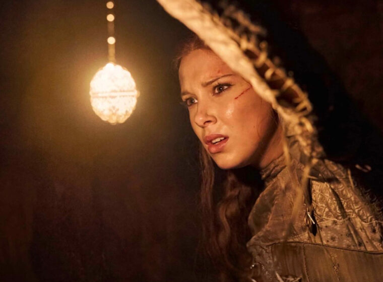 Millie Bobby Brown holding up a light in Damsel | Agents of Fandom