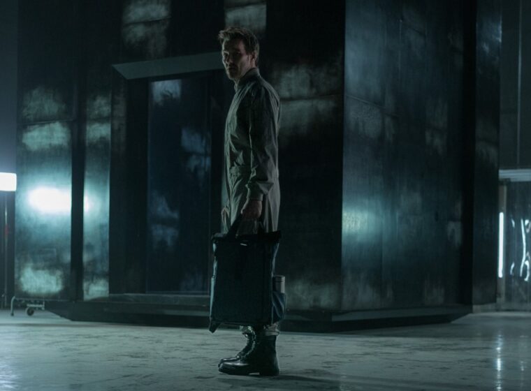 Joel Edgerton as Jason Dessen holding a backpack standing in front of the box in Dark Matter | Agents of Fandom