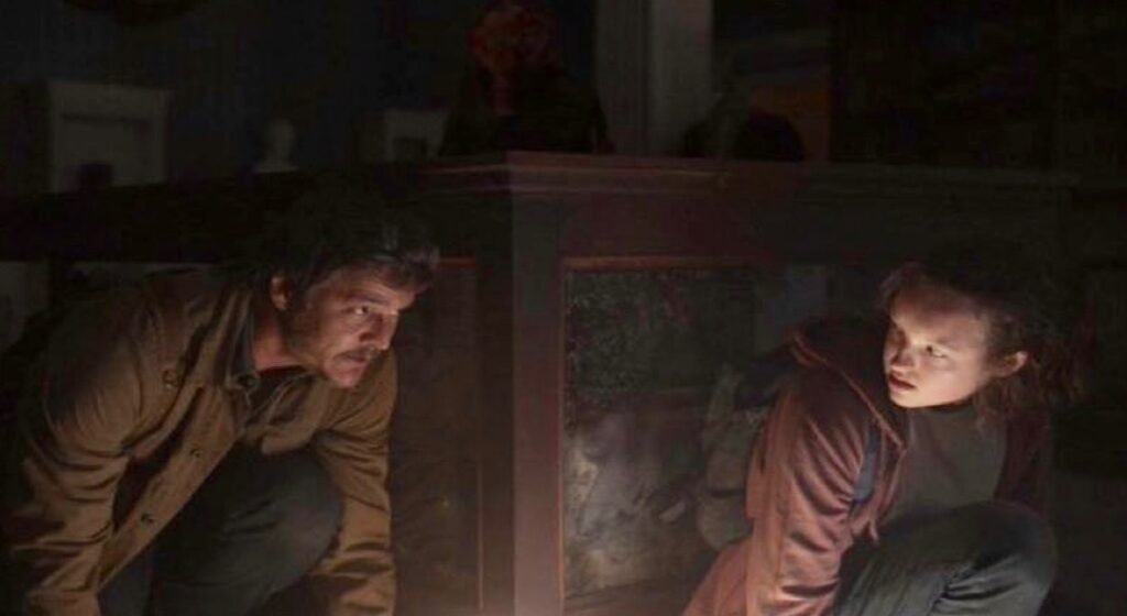 Pedro Pascal (Joel) and Bella Ramsey (Ellie) hiding from Clicker in The Last of Us