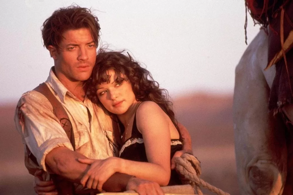 Rick O'Connel (Brendan Fraser) holds Evelyn Carnahan (Rachel Weisz) as they ride through the desert together | Agents of Fandom 