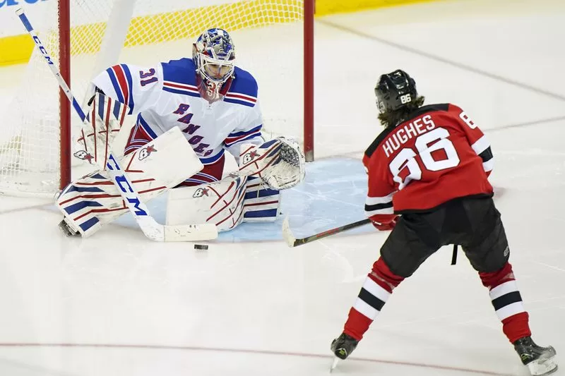 New York Rangers goaltender Igor Shesterkin (31) making a save against New Jersey Devils center Jack Hughes (86) during a game between the two teams | Agents of Fandom