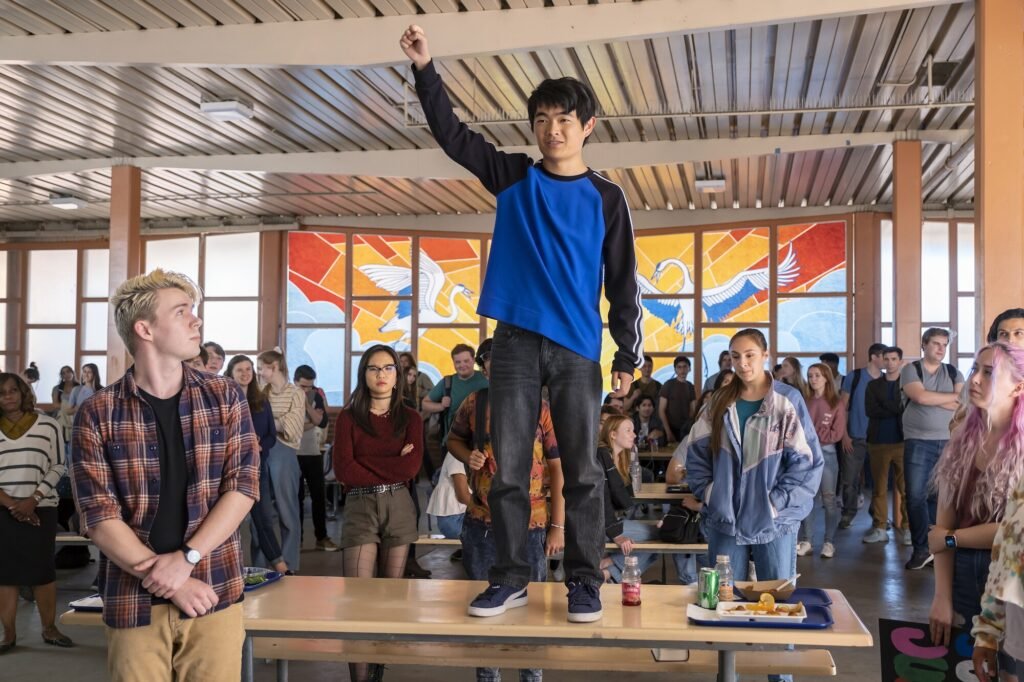 Ben Wang standing on a table during school lunch in American Born Chinese show | Agents of Fandom