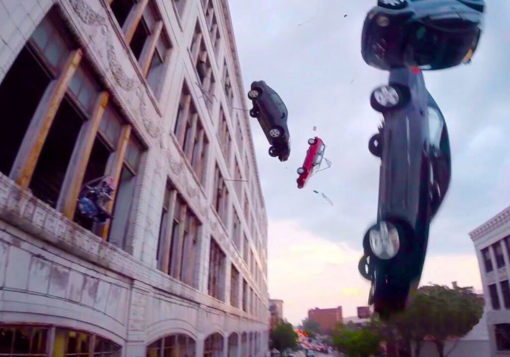 Multiple vehicles pictured falling off of a building during The Fate of the Furious | Agents of Fandom