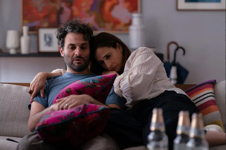 Mark (Arian Moayed, left) is held by Sarah (Michaela Watkins, right) as he copes with his failed acting career. I Agents of Fandom