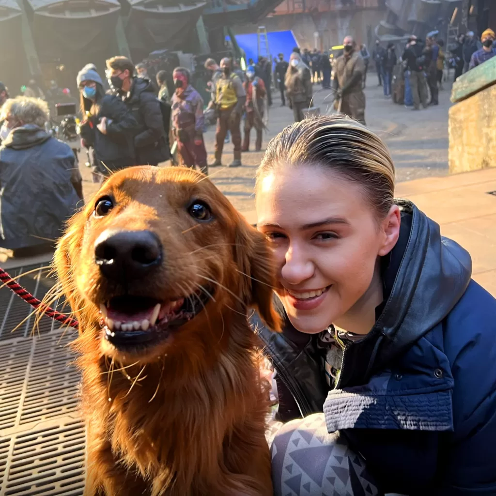 Maria Bakalova smiling with Slate the dog on the set of Guardians of the Galaxy Vol. 3 | Agents of Fandom