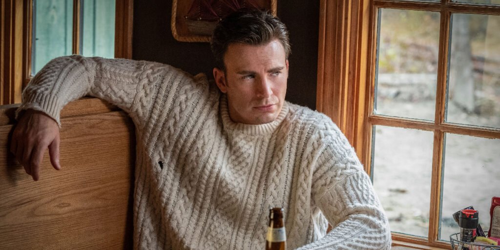 Chris Evans as Ransom Drysdale wearing a white sweater, sitting in a booth drinking a beer in Knives Out | Thanksgiving movies | Agents of Fandom