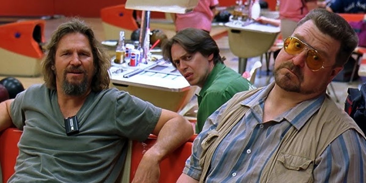 Jeff Bridges as The Dude, Steve Buscemi as Theodore Donald 'Donny' Kerabatsos, and John Goodman as Walter Sobchak sitting together in a bowling alley in The Big Lebowski | Agents of Fandom
