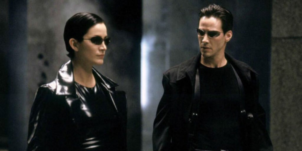 Carrie-Anne Moss as Trinity and Keanu Reeves as Neo standing together in The Matrix | Agents of Fandom