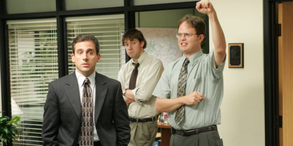 Steve Carell, John Krasinski, and Rainn Wilson standing together in The Office | Agents of Fandom
