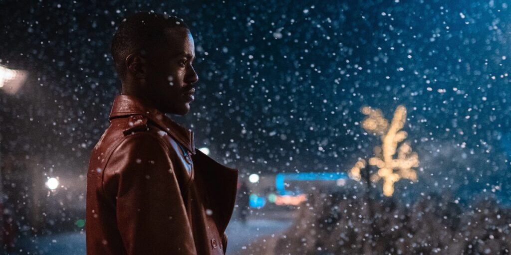Ncuti Gatwa as the fifteenth doctor stands in the midst of falling snow in the Doctor Who Christmas special titled "The Church on Ruby Road" | Agents of Fandom