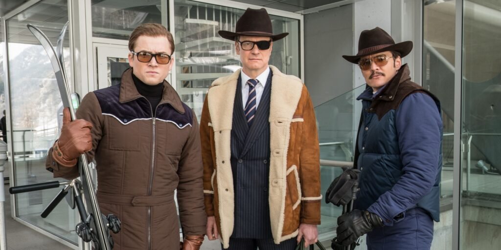 Targon Egerton, Colin Firth and Pedro Pascal stand waiting to ski in Kingsman: The Golden Circle | Agents of Fandom