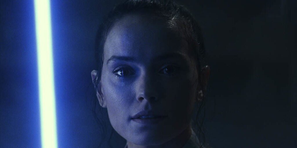 Daisy Ridley as Rey Skywalker holding her blue lightsaber | Agents of Fandom