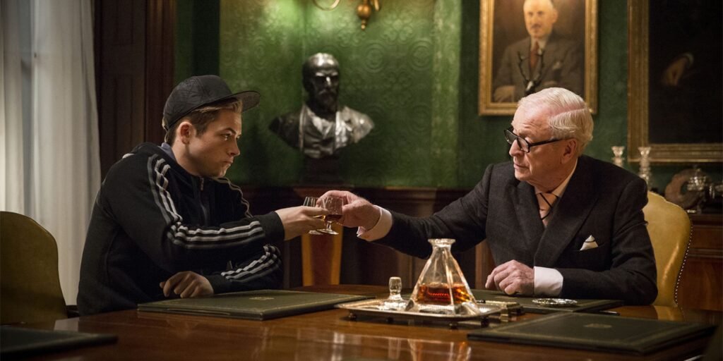 Taron Egertons character sat toasting a drink with Michael Caine's character in Kingsman: The Secret Service | Agents of Fandom