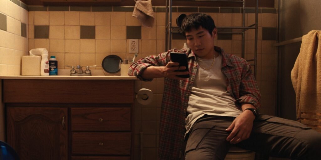 Young Mazino as Paul Cho lounging around on his phone in the bathroom in Netflix's 'Beef.' | Agents of Fandom