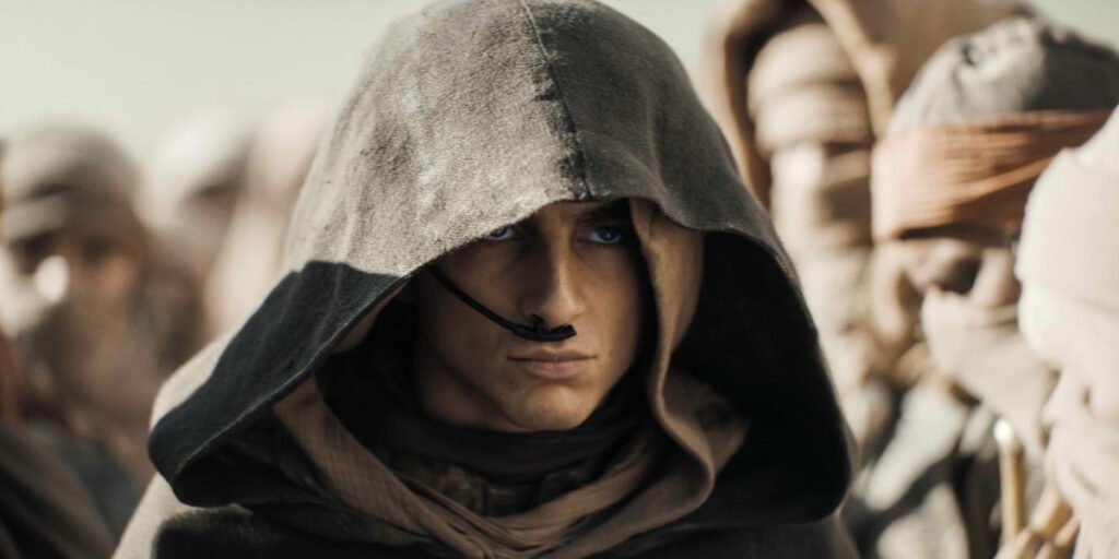 A close up still of Timothée Chalamet wearing a hood in Dune: Part Two | Agents of Fandom