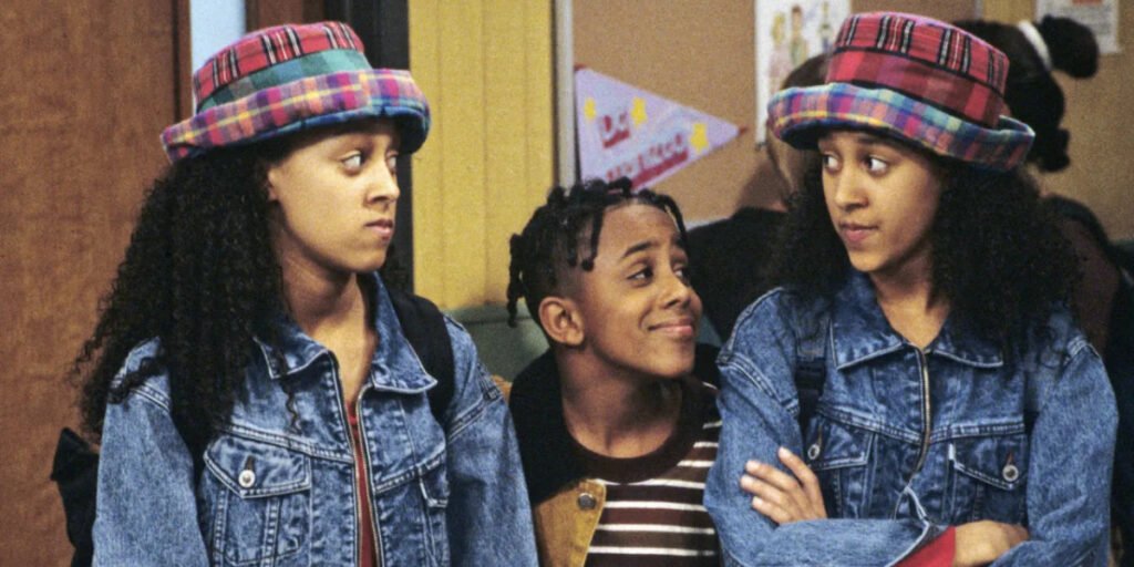 Tia Mowry and Tamera Mowry stand beside co-star Marques Houston in one of the top Black sitcoms of the 1990s, 'Sister, Sister' | Agents of Fandom