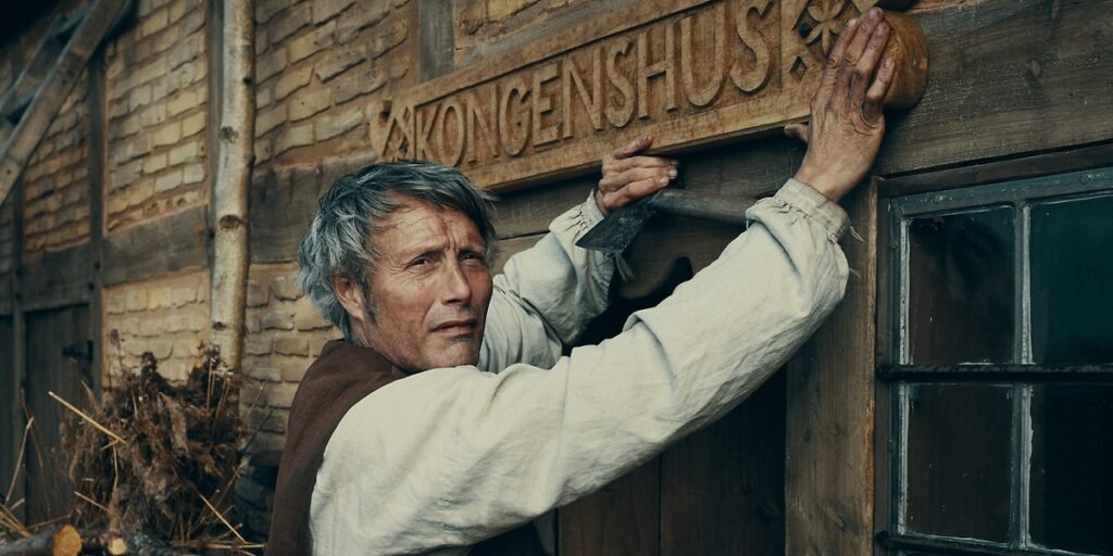 Kahlen (Mads Mikkelsen) posts a wooden sign above his stead in his journey for legacy in The Promised Land. I Agents of Fandom