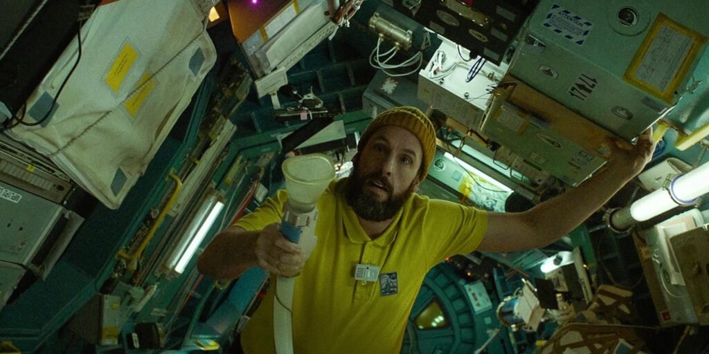 Adam Sandler as Jakub Prochazka aboard the spaceship holding a breathalyzer in Spaceman | Agents of Fandom