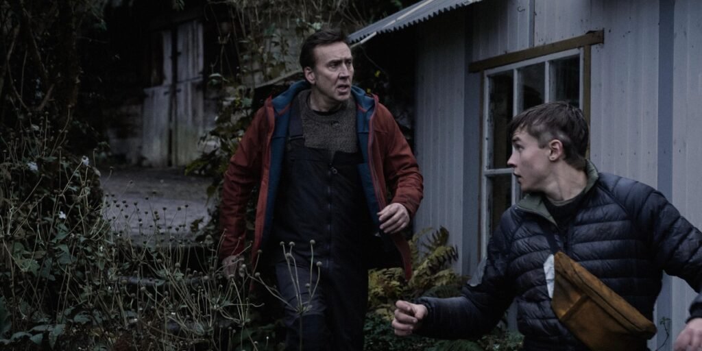 Paul (Nic Cage, center) and his son Thomas (Maxwell Jenkins, right) run around their property to search for shelter before nightfall in Arcadian. Image Credit: RLJE Films