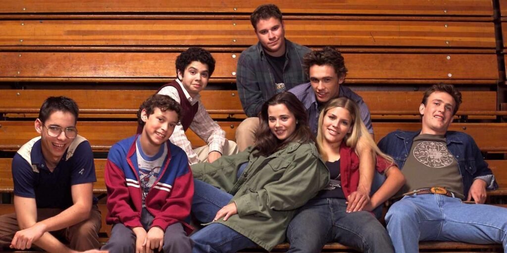 The cast of “Freaks and Geeks" sits back on the gymnasium bleachers. | Agents of Fandom