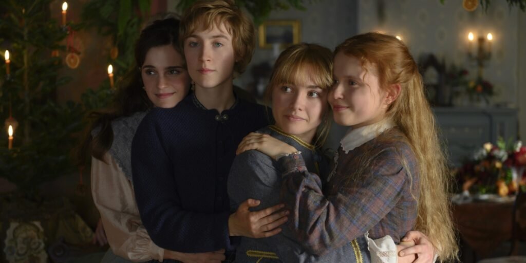 Four young women (From left to right-Emma Watson, Saoirse Ronan, Florence Pugh, Eliza Scanlen) embrace surrounded by Christmas decorations | Agents of Fandom 