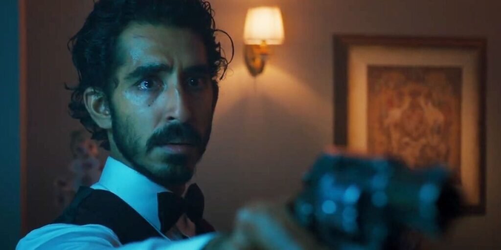 Dev Patel holds a gun out at an off-screen enemy in Monkey Man I Agents of Fandom