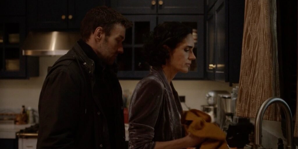 Jennifer Connelly standing at a sink with Joel Edgerton standing behind her in Dark Matter Episode 1 | Agents of Fandom