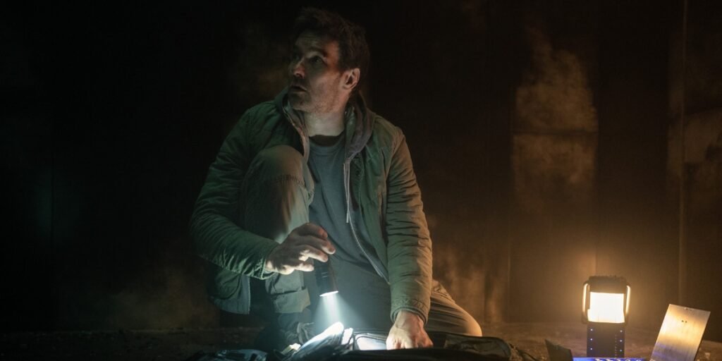 Joel Edgerton looking up inside the box while holding a flashlight in Dark Matter | Agents of Fandom