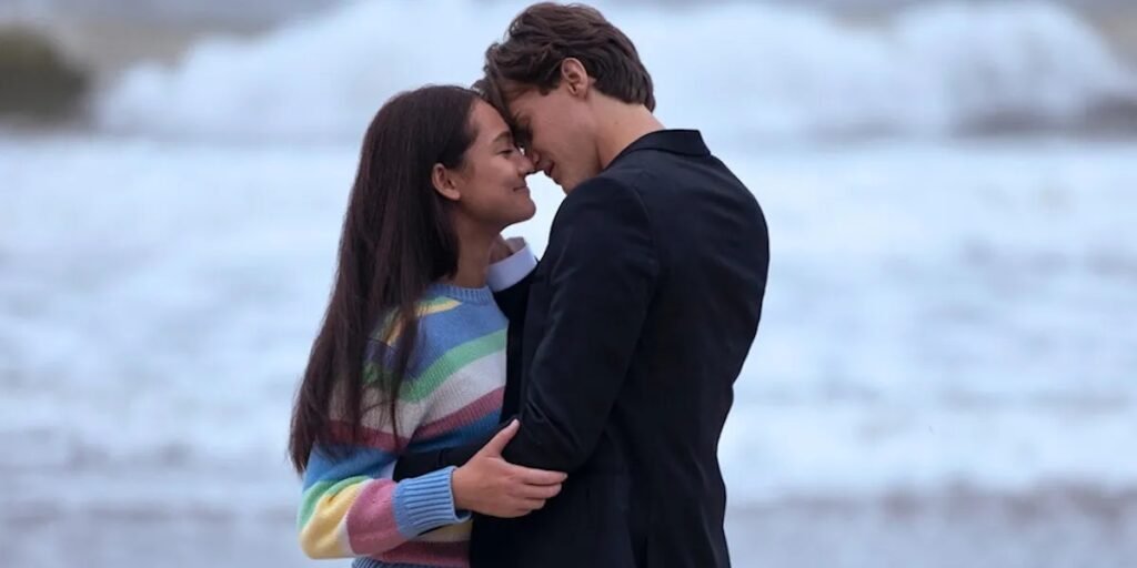 Isabel Conklin (lola tung) and Conrad Fisher (Christopher Briney) locking in a close embrace in front of the ocean in Prime Video's The Summer I Turned Pretty | Agents of Fandom