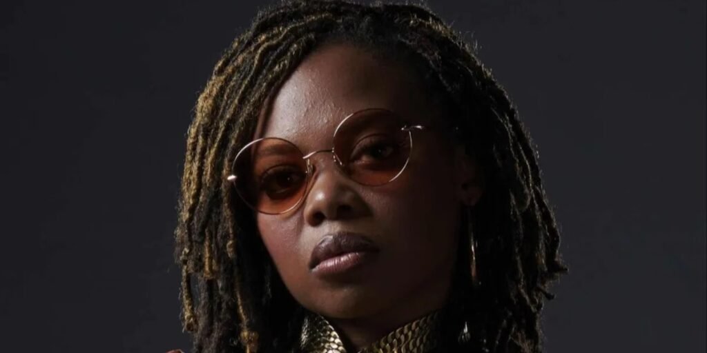 Close-up of Susan Heyward as Sister Sage, wearing her costume and circular glasses | Agents of Fandom