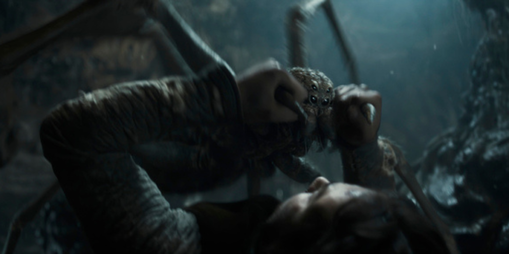 A young Shelob attacks Isildur, pinning him on the ground as he holds back her fangs in The Lord of the Rings: The Rings of Power Season 2 | Agents of Fandom.
