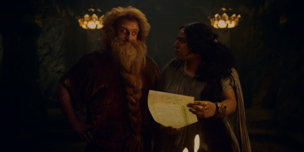 Owain Arthur Prince Durin IV and Sophia Nomvete as Princess Disa looking at a letter in their home of Khazad-dǔm in The Lord of the Rings: The Rings of Power Season 2 | Agents of Fandom