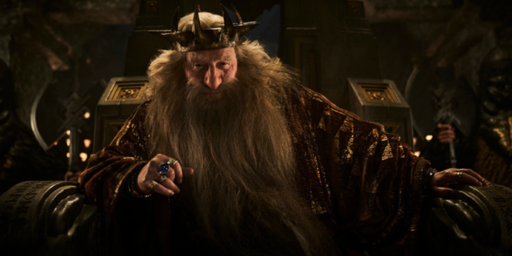 Peter Mullan as King Durin III sitting on his throne and wearing his ring of power in The Lord of the Rings: The Rings of Power Season 2 | Agents of Fandom