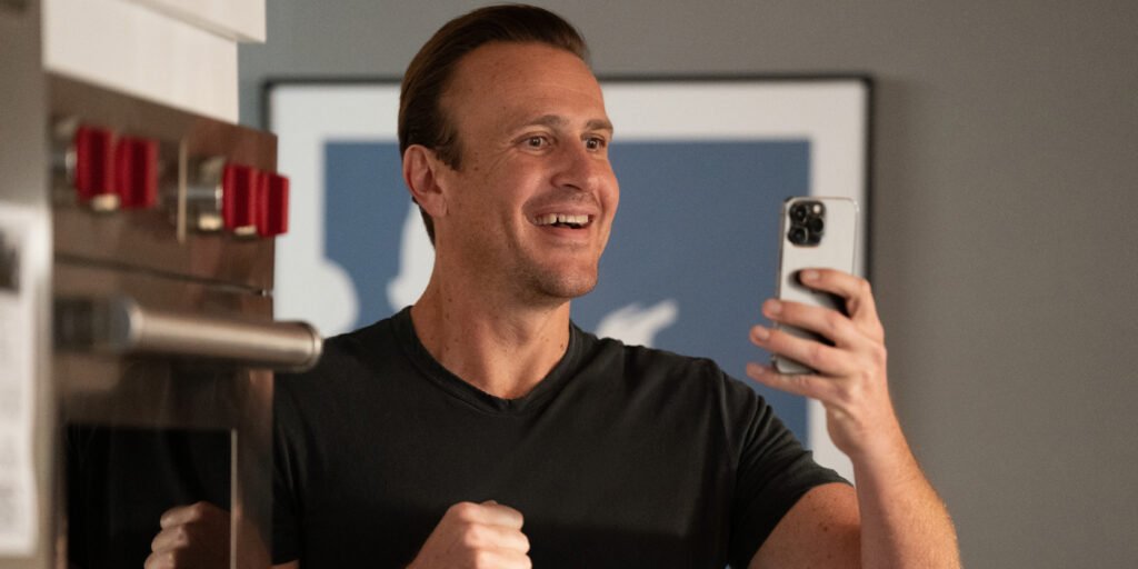 Jason Segel smiling as he looks at his phone in Shrinking Season 2 | Agents of Fandom