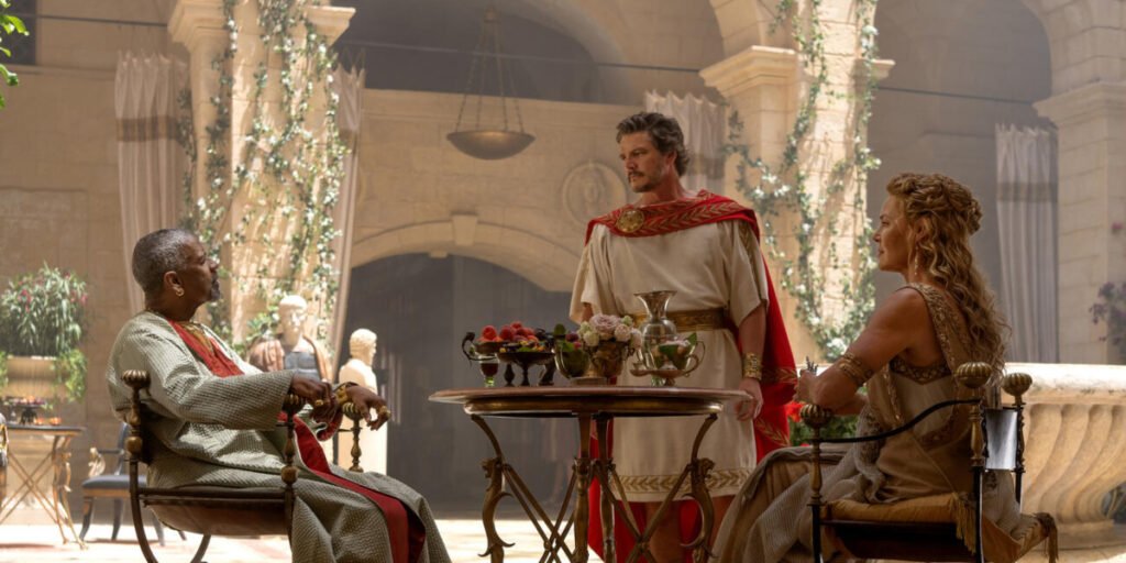 Macrinus (Denzel Washington), Marcus Acacius (Pedro Pascal), and Lucilla (Connie Nielsen) talking to each other in a courtyard in Gladiator 2 | Agents of Fandom