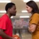 Walt (Shameik Moore) holding a bowling ball designed as a basketball while smiling at Skunk (D'Arcy Carden) in The Gutter | Agents of Fandom