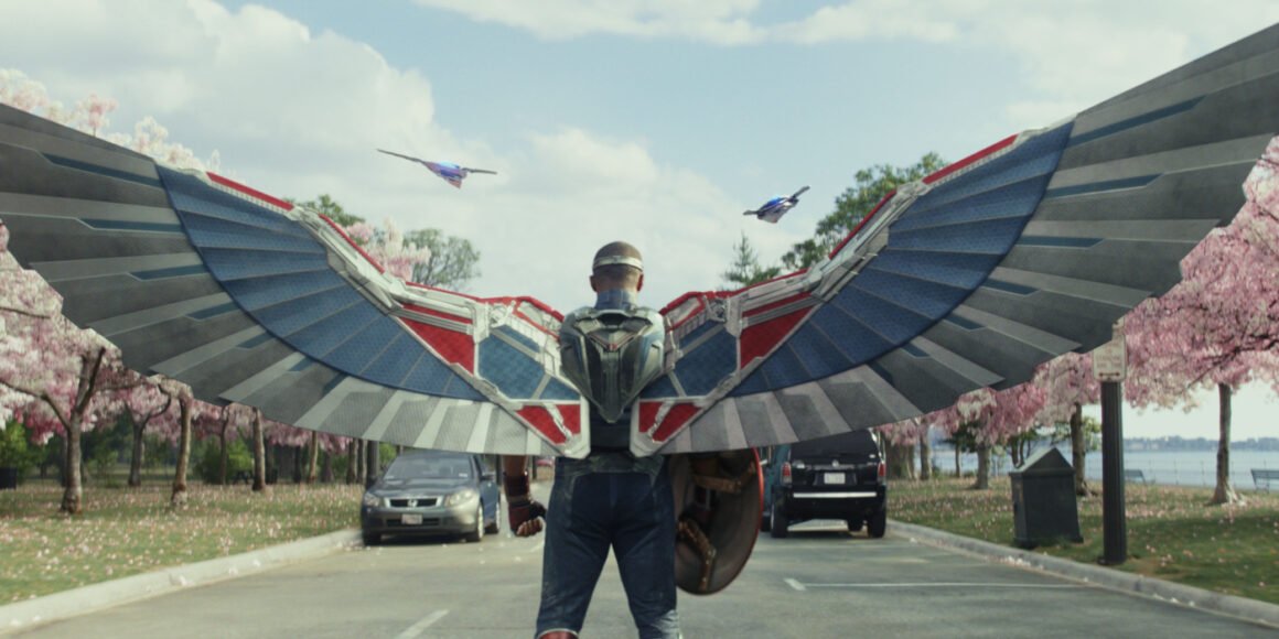 Captain America (Anthony Mackie) with his wings out in a park with cherry blossoms in Captain America: Brave New World | Agents of Fandom