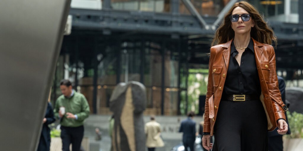 Cate Blanchett wearing a brown coar and sunglasses, walking outside in Steven Soderbergh's Black Bag | Agents of Fandom