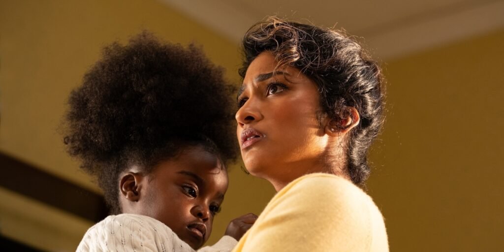 Belinda (Varada Sethu) holding Poppy (Sienna-Robyn Mavanga-Phipps) | Agents of Fandom