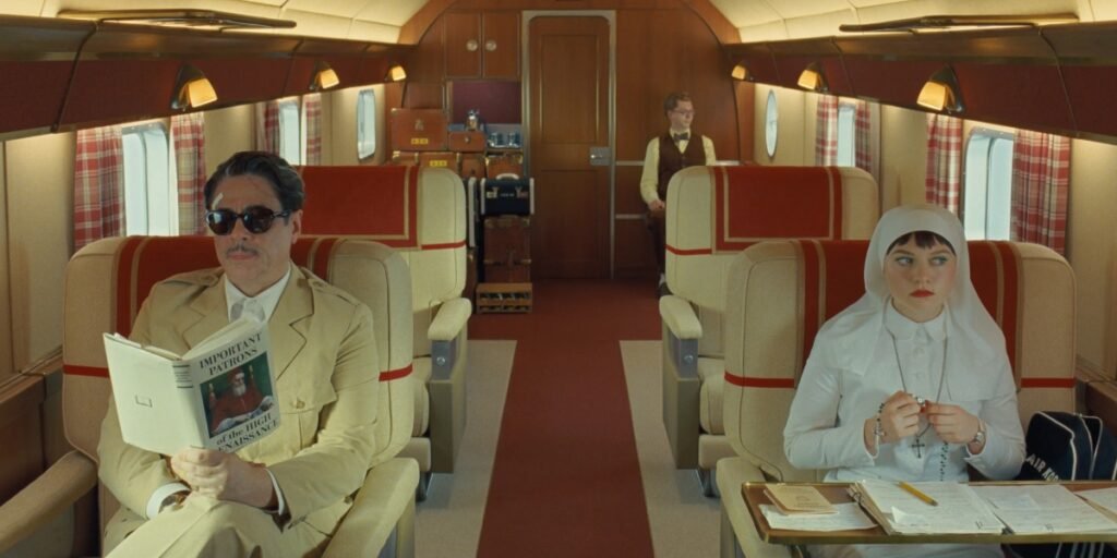 Benicio Del Toro, Michael Cera, and Mia Threapleton on a train in The Phoenician Scheme | Agents of Fandom