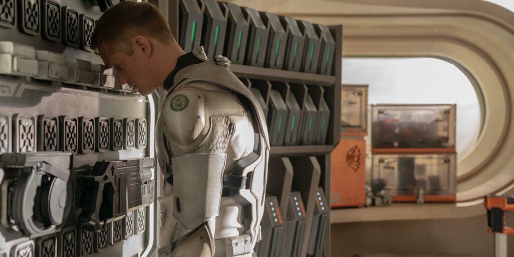 Alexander Skarsgård as Murderbot leaning his head against a wall | Agents of Fandom
