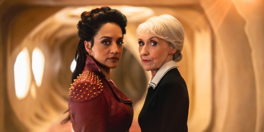 The Rani (Archie Panjabi) and Mrs Flood (Anita Dobson) standing next to each other in Doctor Who Season 2 | Agents of Fandom