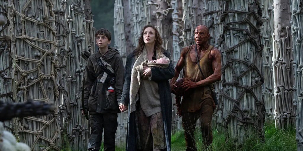 Jodie Comer, Alfie Williams, and Ralph Fiennes walk through a forest of bones in 28 Years Later | Agents of Fandom