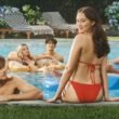 Conrad (Christopher Briney) looks up at Belly (Lola Tung) who is sitting with her back to the camera and head turned around. Jeremiah (Gavin Casalegno), Taylor (Rain Spencer), and Steven (Sean Kaufman) are in the background. | Agents of Fandom