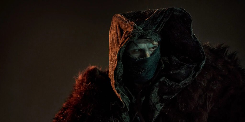 The Creature (Jacob Elordi) wearing a big hood and a fur coat in Guillermo del Toro's Frankenstein | Agents of Fandom