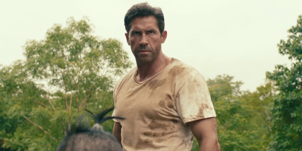 Scott Adkins staring over the head of a man with a bun in his hair in Prisoner of War | Agents of Fandom