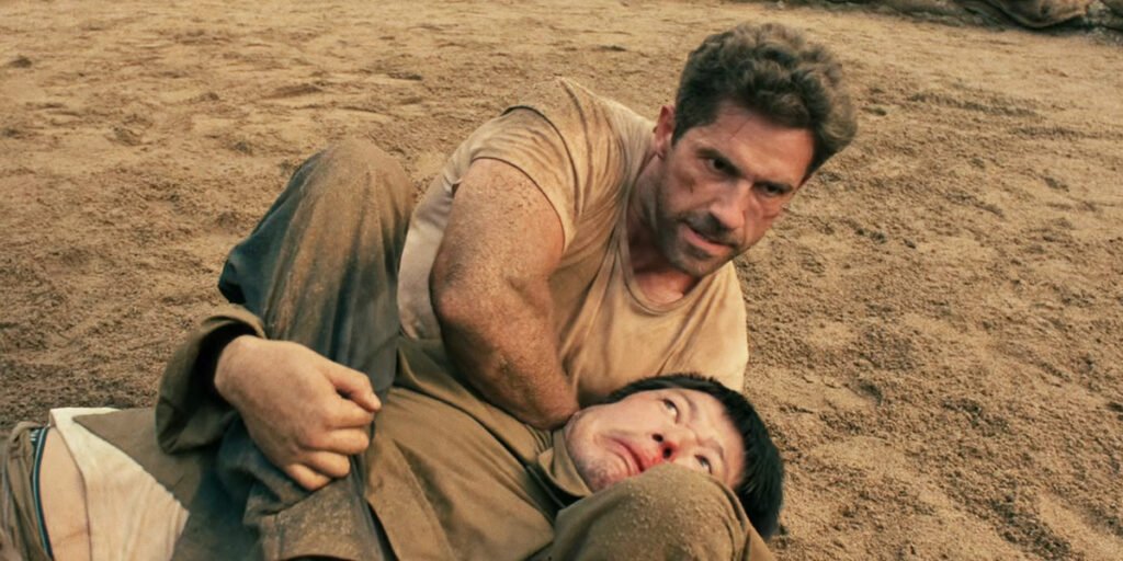 Scott Adkins with his legs around an enemy's neck in Prisoner of War | Agents of Fandom