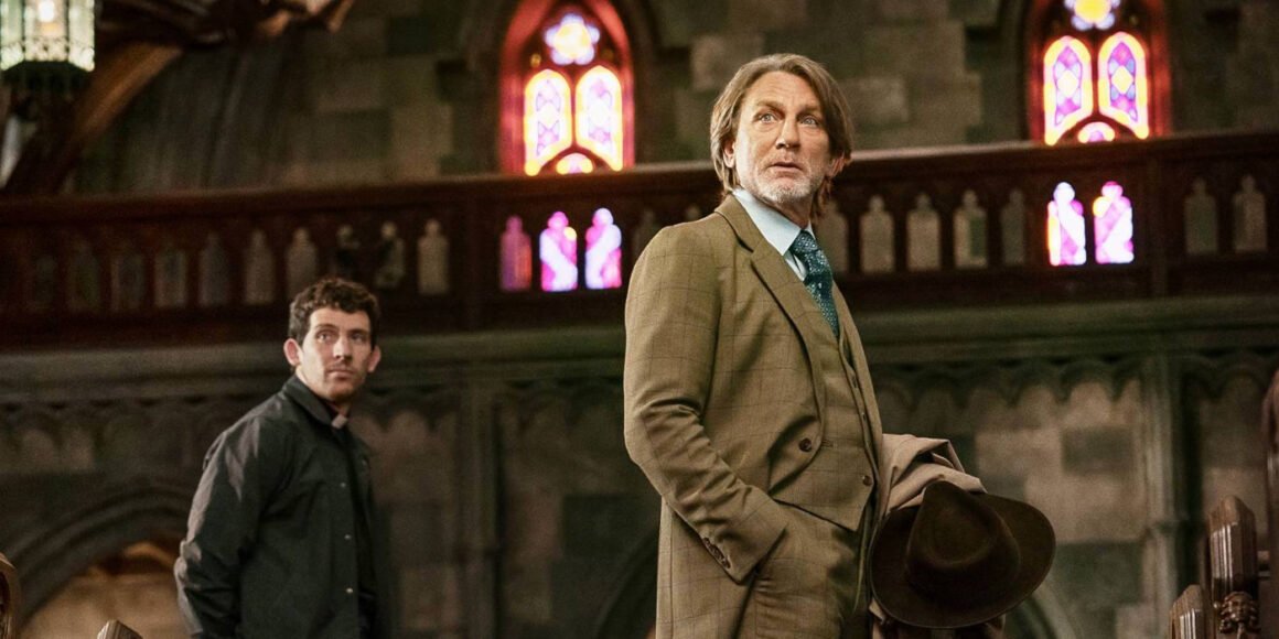 Jud Duplenticy (Josh O'Connor) and Benoit Blanc (Daniel Craig) staring at the front of a church in Wake Up Dead Man: A Knives Out Mystery | Agents of Fandom