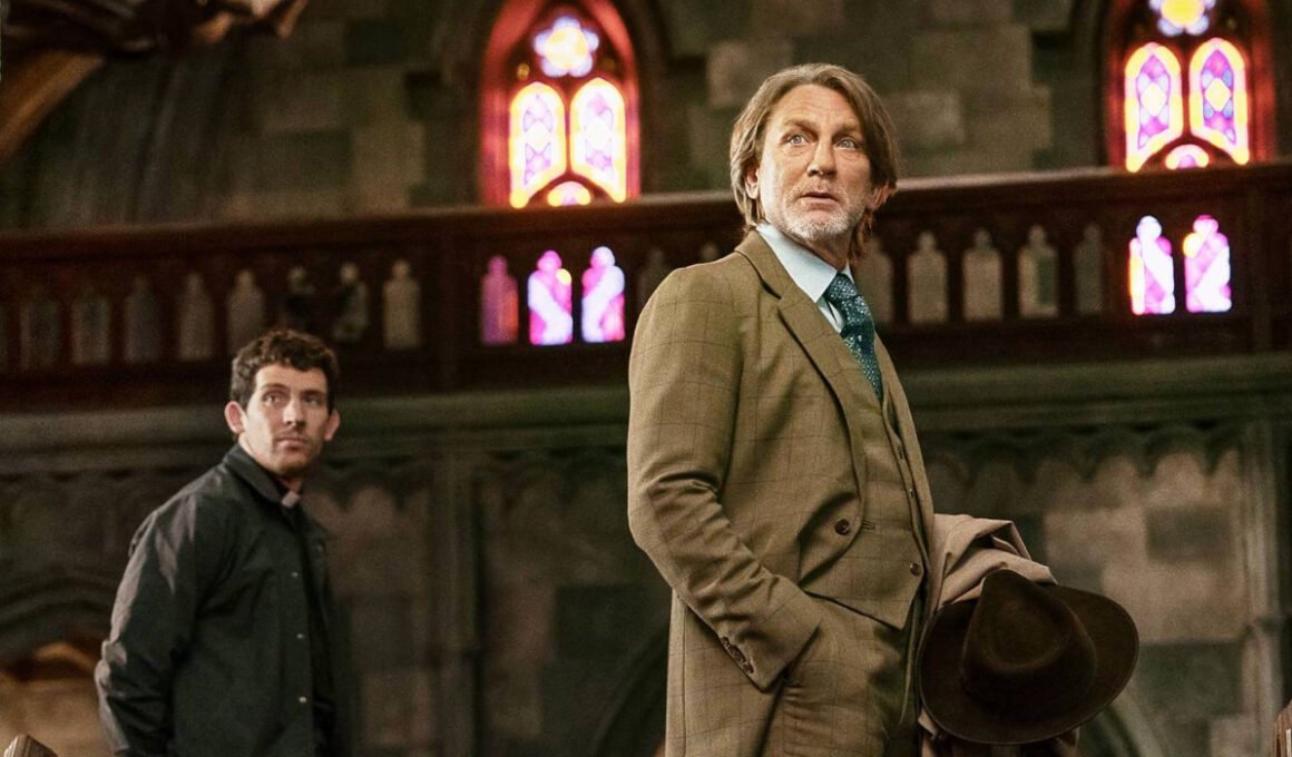 Jud Duplenticy (Josh O'Connor) and Benoit Blanc (Daniel Craig) staring at the front of a church in Wake Up Dead Man: A Knives Out Mystery | Agents of Fandom